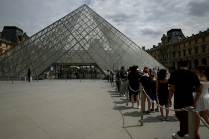 Des visiteurs font la queue devant la pyramide de l'architecteIeoh Ming Pei au musée du Louvre à Paris, le 11 juillet 2024 Des visiteurs font la queue devant la pyramide de l'architecteIeoh Ming Pei au musée du Louvre à Paris, le 11 juillet 2024