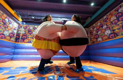 Des visiteuses, en costumes rembourrés, se battent dans l'"arène de sumo" au musée du rire HaHaHouse à Zagreb, le 21 janvier 2025 en Croatie Des visiteuses, en costumes rembourrés, se battent dans l'"arène de sumo" au musée du rire HaHaHouse à Zagreb, le 21 janvier 2025 en Croatie