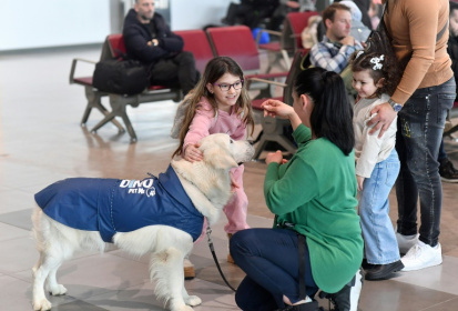 Des enfants s'approchent de Dino, un golden retriever conduit par sa dresseuse Vesna Kiskovska (d) à l'aéroport international de Skopje, le 29 janvier 2025 en Macédoine du Nord Des enfants s'approchent de Dino, un golden retriever conduit par sa dresseuse Vesna Kiskovska (d) à l'aéroport international de Skopje, le 29 janvier 2025 en Macédoine du Nord