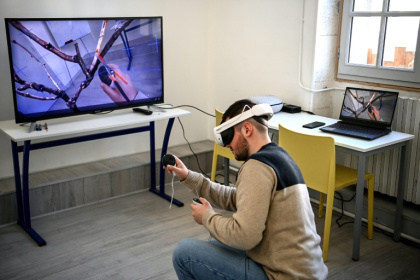 Un étudiant de l'Institut Richemont utilise le logiciel Ampelos lors d'une formation sur la taille de la vigne avec un masque de réalité virtuelle, à Val-de-Cognac, le 17 février 2025 en Charente