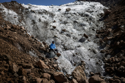 Le guide de randonnée Charles Kibaki Muchiri observe le paysage, assis au pied du glacier Lewis, près du sommet du mont Kenya, dans le parc national du mont Kenya, le 7 mars 2025 Le guide de randonnée Charles Kibaki Muchiri observe le paysage, assis au pied du glacier Lewis, près du sommet du mont Kenya, dans le parc national du mont Kenya, le 7 mars 2025