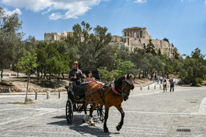 Des touristes en calèche passent devant la colline de l'Acropole, le 29 mai 2025 à Athènes - Aris MESSINIS (AFP) Des touristes en calèche passent devant la colline de l'Acropole, le 29 mai 2025 à Athènes - Aris MESSINIS (AFP)
