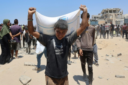 Des personnes se déplacent dans la rue al-Rashid, dans l'ouest de Jabalia, le 22 juillet 2025, après avoir reçu une aide humanitaire dans un centre de distribution situé dans le nord de la bande de Gaza - Omar AL-QATTAA (AFP) Des personnes se déplacent dans la rue al-Rashid, dans l'ouest de Jabalia, le 22 juillet 2025, après avoir reçu une aide humanitaire dans un centre de distribution situé dans le nord de la bande de Gaza - Omar AL-QATTAA (AFP)