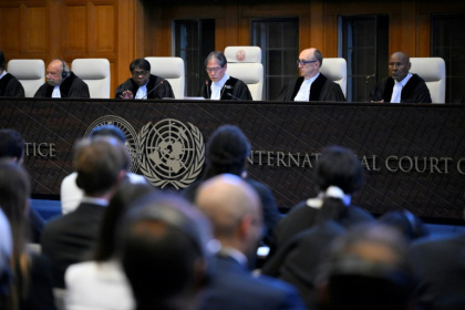 Le président de la Cour de justice internationale Yuji Iwasawa (C) présente la premier avis consultatif de l'institution sur les obligations légales des pays face au changement climatique, le 25 juillet 2025 à La Haye - JOHN THYS (AFP)