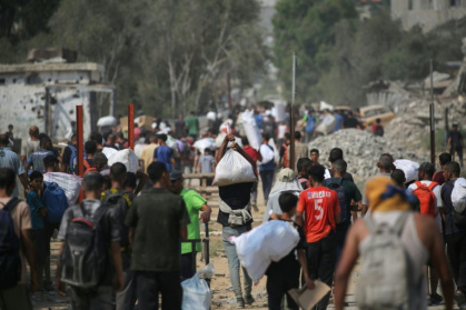 Déplacés palestiniens transportant des sacs d'aide humanitaire après une distribution à Nousseirat, dans le centre de la bande de Gaza, le 26 juillet 2025 - Eyad BABA (AFP) Déplacés palestiniens transportant des sacs d'aide humanitaire après une distribution à Nousseirat, dans le centre de la bande de Gaza, le 26 juillet 2025 - Eyad BABA (AFP)