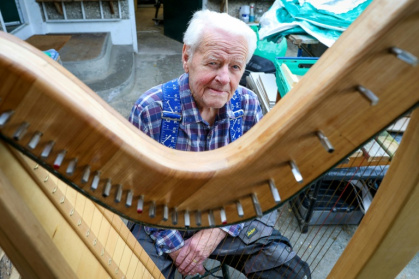 Noel Anderson, 89 ans, pose dans son atelier de fabrication de harpes, le 29 septembre 2025 à Strabane, en Irlande du Nord - Paul Faith (AFP)