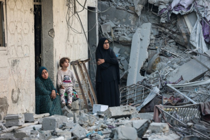 Des femmes et un enfant au milieu des décombres d'une maison détruite lors d'une frappe israélienne nocturne à Gaza, le 29 octobre 2025 - Omar AL-QATTAA (AFP)