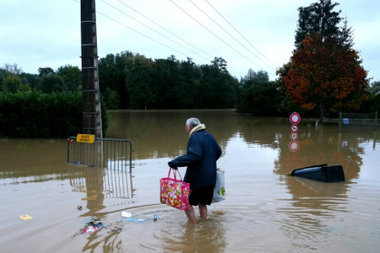 Un habitant se déplace à pied dans une rue inondée de Pommeuse, en Seine-et-Marne, le 10 octobre 2014, après un épidode de fortes pluies - Dimitar DILKOFF (AFP)