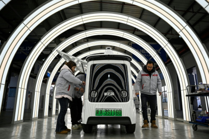 Des ouvriers travaillent sur une ligne de production de l'usine Neolix qui fabrique de petits véhicules utilitaires autonomes pour le transport de colis en ville, le 4 décembre 2025 à Yancheng dans la province chinoise du Jiangsu - Jade GAO (AFP)