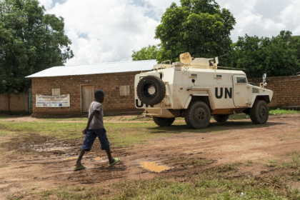 Un enfant passe devant un blindé de la Minusca à Maloum, en Centrafrique, le 24 juillet 2025 - Mariam KONE (AFP)