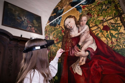 Une experte travaille à la restauration de "La Vierge au buisson de roses" peinte en 1473 par Martin Schongauer, le 5 mars 2026 dans l'église des Dominicains à Colmar, dans le Haut-Rhin - SEBASTIEN BOZON (AFP)