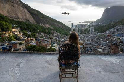 Une touriste se fait filmer par un drone sur le toit d'une maison dans la favela de Rocinha, à Rio de Janeiro, au Brésil, le 5 mars 2026 - Pablo PORCIUNCULA (AFP)