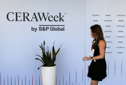 Une femme passe devant un panneau de la CERAWeek, plus grand rassemblement annuel des acteurs du pétrole, le 22 mars 2026 à Houston, au Texas - JULIEN DE ROSA (AFP)