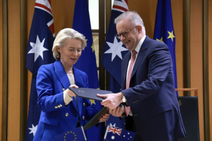 La présidente de la Commission européenne Ursula von der Leyen et le Premier ministre australien Anthony Albanese échangent des copies de l'accord commercial Australie-UE, le 24 mars 2026 à Canberra - DAVID GRAY (AFP)
