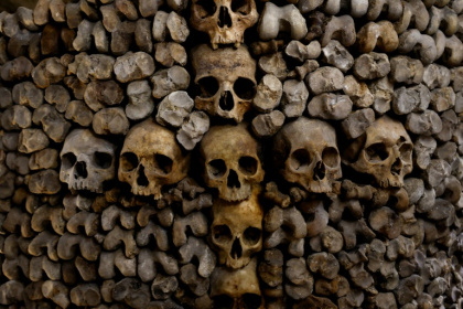 Des crânes et des ossements humains alignés contre un mur des catacombes de Paris, le 24 mars 2026 - Kenzo TRIBOUILLARD (AFP)