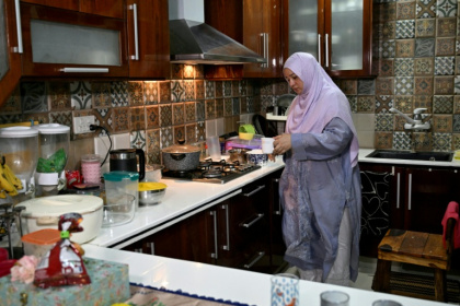 Saniya Jafri, médecin et praticienne en télémédecine pour la société de santé numérique Sehat Kahani, prépare du thé pendant une pause entre deux consultations en ligne à son domicile de Karachi, au Pakistan, le 7 avril 2026 - Rizwan TABASSUM (AFP)