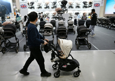 Un homme avec sa poussette dans une allée d'un salon de l'enfant, le 30 avril 2026 à Séoul - Jung Yeon-je (AFP)
