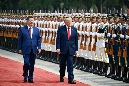 Le président américain Donald Trump (droite) et son homologue chinois Xi Jinping passent des troupes en revue, le 14 mai 2026 à Pékin - Kenny HOLSTON (AFP)