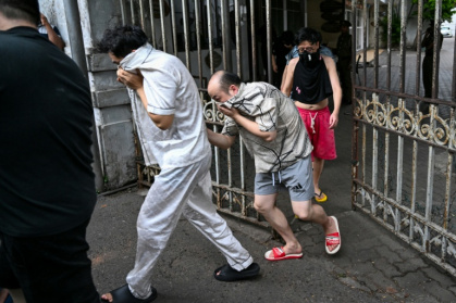 Des ressortissants chinois suspectés d'appartenir à un réseau de cybercriminalité sont escortés vers une prison sri-lankaise après leur arrestation à Colombo, le 9 mai 2026 - Ishara S. KODIKARA (AFP)