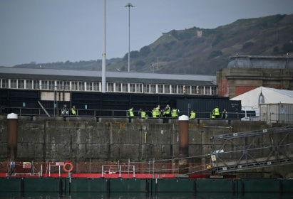 Des membres des forces de l'ordre britanniques attendent sur un quai pour accueillir des migrants récupérés en mer alors qu'ils tentaient de traverser la Manche, au port de Douvres, sur la côte sud de l'Angleterre, le 5 avril 2023 - Ben Stansall (AFP)