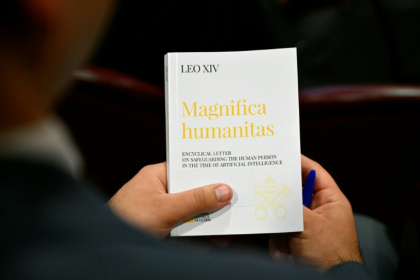 Une personne tient l'encyclique "Magnifica Humanitas" consacrée à l'essor de l'intelligence artificielle, le jour de sa promulgation par le pape Léon XIV, le 25 mai 2026 au Vatican - Alberto PIZZOLI (AFP)