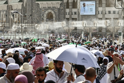 Des fidèles musulmans déambulent dans le complexe de la Grande Mosquée sous les brumisateurs installés dans la ville sainte de La Mecque, le 24 mai 2026  en Arabie saoudite, à la veille du pèlerinage annuel du Hajj - Zain JAAFAR (AFP)