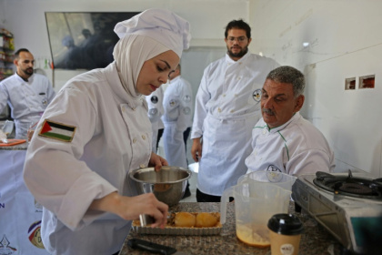 Des jeunes Palestiniens apprennent les bases de la cuisine à la Smile Kitchen Academy, dans le quartier de Rimal à Gaza, le 24 juin 2026 - Omar AL-QATTAA (AFP)
