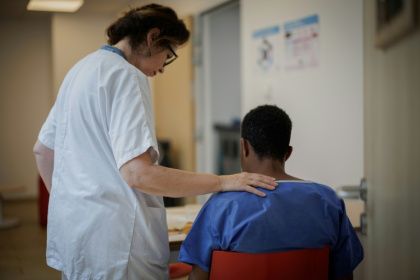Une aide-soignante encourage un patient en salle des repas du Centre renforcé d'urgences psychiatriques de l'hôpital Delafontaine à Saint-Denis en Seine-Saint-Denis le 17 juin 2026 - Simon WOHLFAHRT (AFP)