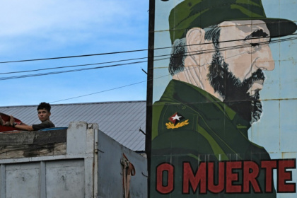 Un jeune homme près d'un portrait de Fidel Castro, à La Havane, le 10 août 2026 - YAMIL LAGE (AFP)