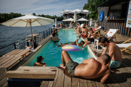 Des clients se prélassent au bord de la piscine de Foil in Paris, en bord de Seine, le 2 août 2026 - Simon WOHLFAHRT (AFP)