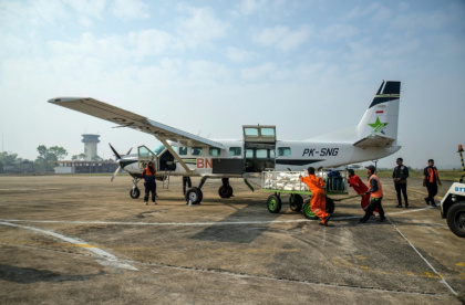 Des agents de l'Agence nationale de gestion des catastrophes chargent du chlorure de sodium dans un avion avant une opération d'ensemencement des nuages à Palangkaraya, dans le Kalimantan central, le 2 août 2026 en Indonésie - REINA (AFP)
