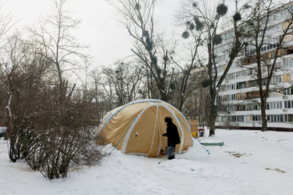 Une femme entre dans une tente proposant des services d'urgence, installée pour les personnes dont les logements sont privés d'électricité ou de chauffage, à Kiev, le 18 février 2026 - Tetiana DZHAFAROVA (AFP)