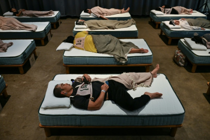 Des participants à une compétition de sommeil organisée par une entreprise de literie à Tokyo, le 5 octobre 2026 au Japon - Selim CHTAYTI (AFP)